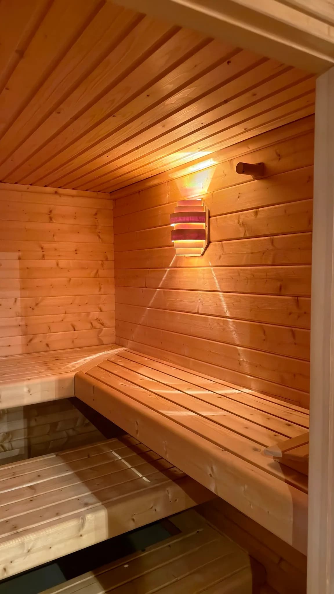 Saunaraum mit Holzverkleidung und Ruhebereich.